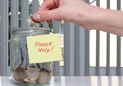 Hand putting money into a jar